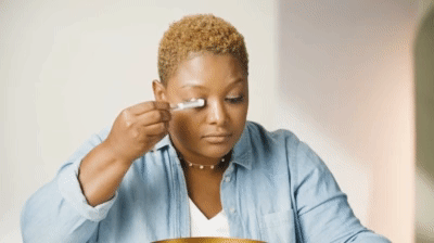 woman gently cleaning her lash extensions
