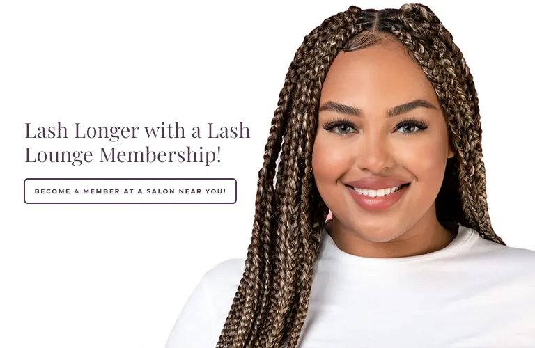 Black woman in a white tshirt smiling in front of a grey background.